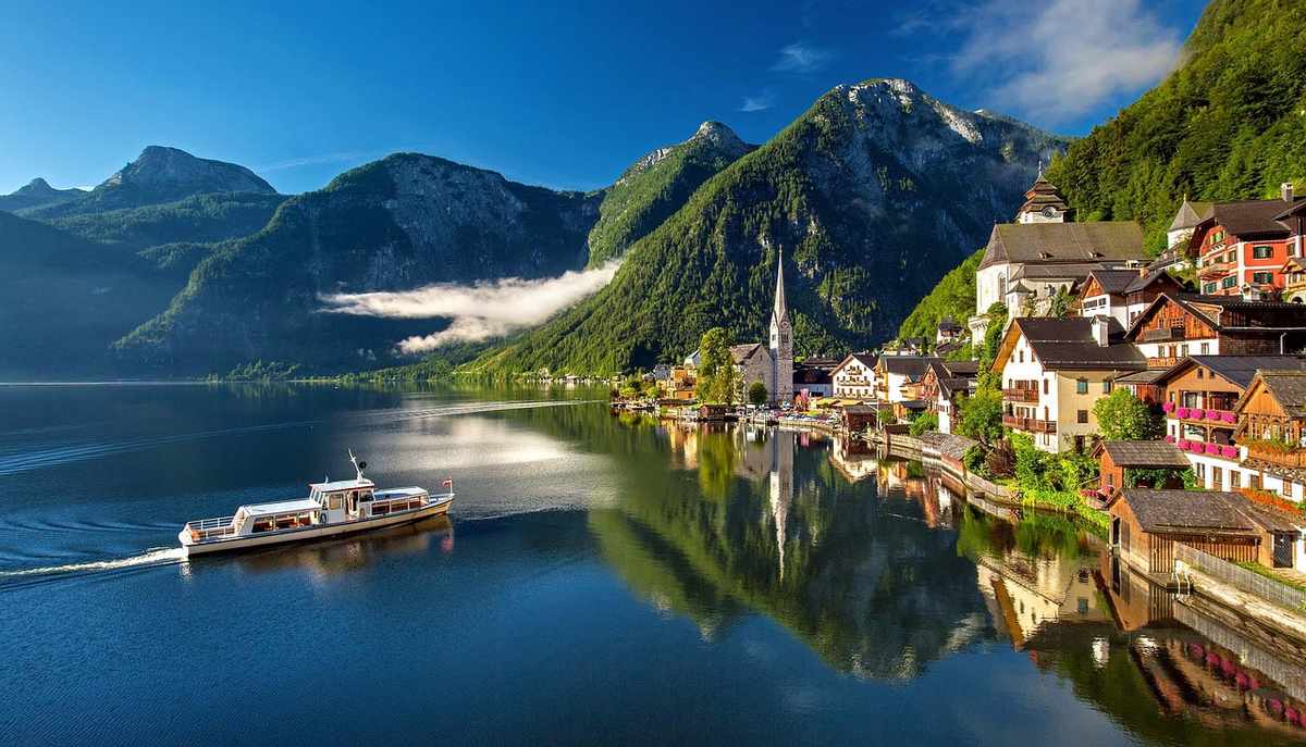 Un village pittoresque au bord d'un lac calme entouré de montagnes verdoyantes Un village pittoresque au bord d'un lac calme entouré de montagnes verdoyantes